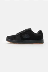 Championes deportivos DC Shoes, modelo Mantis, en color negro con suela de goma color camel. Diseño de estilo skate con cordones anchos y el logotipo de la marca en el lateral.