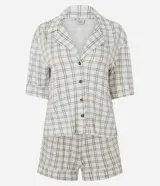 Pijama corto de dos piezas confeccionado en viscolycra con estampado de cuadros. Compuesto por una camisa de mangas cortas con cuello de solapa y cierre frontal de botones, y un short con cintura elastizada.
