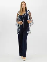 Conjunto de tres piezas compuesto por una musculosa de silueta recta, un pantalón de seda fría con caída fluida y cintura elastizada, y un kimono de tul con bordado floral, frente abierto y mangas acampanadas. Incluye collar largo removible.