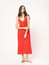 Vestido largo color crudo de lino, con silueta recta, escote en V, breteles anchos, detalle de elástico en la espalda y tajos laterales.