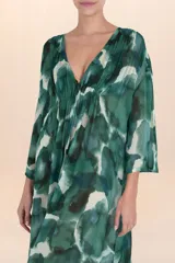 Kaftán largo de tela ligera y semitransparente con estampado abstracto en tonos verdes y azules. Presenta escote en V con frunces en el busto y mangas amplias.