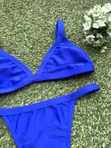 Conjunto de bikini azul eléctrico, con corpiño triangular fijo y bombacha colaless regulable.