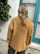 Sweater de tejido de punto color beige, con cuello redondo, mangas largas con puños doblados y diseño holgado.