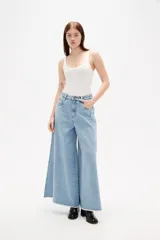 Pantalon de jean azul de corte ancho y tiro alto, con ruedo deshilachado.