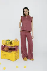 Pantalón de vestir mostaza, de corte palazzo, con bolsillos laterales y detalle de volados rojos en la cintura.