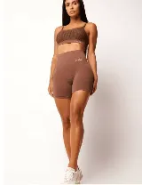 Short deportivo de tiro alto con tecnología seamless, confeccionado en tejido de compresión color marrón. Presenta una cintura ancha acanalada con logo bordado y diseño texturizado que realza la silueta.