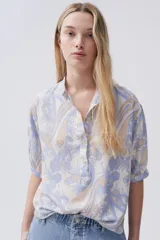 Blusa estampada con botones en el frente y mangas tres cuartos.