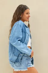 Campera de denim azul de corte oversize, con bolsillos frontales aplicados y cierre con botones metálicos.