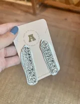 Aros colgantes con forma de lágrima, con base de tela celeste y apliques de strass plateados.