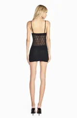 Musculosa negra de tul con aplicaciones de encaje floral, diseño semitransparente, escote corazón y cierre frontal con botones pequeños.