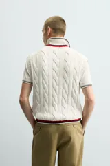 Chaleco de punto con diseño de trenzas, cuello en V y acabado acanalado en el cuello y el ruedo con detalles de rayas en contraste.