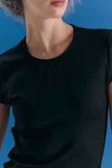 Remera de cuello redondo y manga corta, confeccionada en lycra con textura tipo neoprene. Presenta un calce ajustado al cuerpo y un isologo bordado en el centro del pecho.