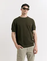 Remera de punto color beige, de manga corta y cuello redondo.