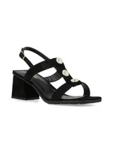 Sandalias de tacón ancho color negro con tiras cruzadas y apliques de botones metálicos dorados en la parte central. Tira ajustable al tobillo con hebilla dorada.