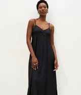 Vestido midi evasê marrón con breteles finos, escote corazón y corte en la cintura. Presenta silueta fluida con caída amplia y bolsillos laterales.