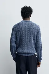 Jersey de punto de algodón con diseño de trenzas verticales, cuello redondo y manga larga con terminaciones en rib.