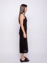 Vestido largo de tejido de punto negro, sin mangas, con escote redondo y detalle de nudo en la espalda.