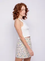 Minifalda de jean color crudo con estampado floral multicolor, con bolsillos delanteros y traseros.