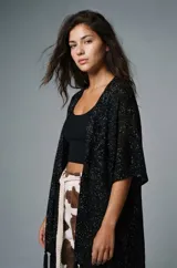 Pantalón ancho de tiro alto con estampado de vaca en tonos marrón y blanco. Se ajusta a la cintura con un cinturón de cuerda trenzada de color crudo.