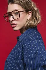 Camisa de manga larga con diseño de rayas verticales y horizontales en color marrón. Presenta un corte oversize con hombros caídos, cuello clásico y cierre frontal con botones.