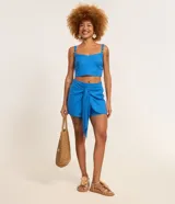 Short pollera corto de viscolino color azul, con cintura elástica y detalle de lazo delantero. Confeccionado en una mezcla de viscosa y lino.