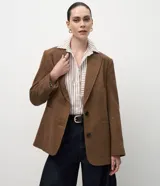 Blazer femenino de corte regular confeccionado en polivelour con textura de espiga. Presenta solapa clásica, mangas largas, cierre frontal con botones y bolsillos funcionales.