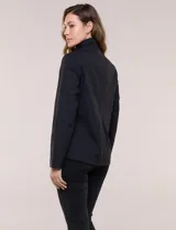 Campera rompevientos deportiva Michael Kors, de color negro, silueta semi entallada y corte a la cadera. Confeccionada en tela técnica liviana, impermeable y elastizada, cuenta con cuello alto, cierre frontal completo termosellado y bolsillos laterales verticales con cierre.