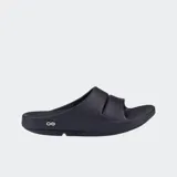 Sandalias de recuperación Oofos modelo Ooahh, color negro, con diseño ergonómico y tecnología OOfoam para mayor absorción de impacto. Presentan una banda ancha superior con abertura central y suela con soporte de arco biomecánico.
