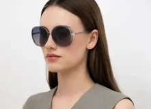 Lentes de sol INVU con montura redonda color celeste y plateado, y cristales degradados de azul a lila.