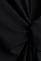 Vestido corto negro de punto con cuello redondo, mangas cortas y detalle de nudo en un lateral.