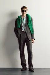 Blazer regular fit de Zara, confeccionada en tejido con mezcla de lana y lino en color gris oscuro con efecto jaspeado. Presenta cuello con solapas de muesca, manga larga con botones en los puños y un cierre frontal de un botón. Incluye bolsillos con solapa en la cadera, un bolsillo de vivo en el pecho y aberturas en la parte trasera.