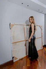 Vestido largo negro de cuero ovino con cierre frontal de cremallera metálica, sin mangas y con tajo lateral.