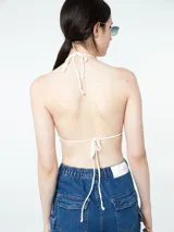 Top tejido al crochet color crudo, con tirantes finos.