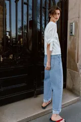 Camiseta de cuello redondo confeccionada en algodón, con mangas cortas abullonadas de tejido bordado perforado y detalle de lazadas en los puños.