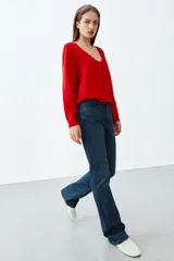 Jeans bootcut de tiro medio color azul oscuro, con cinco bolsillos y pespuntes a contraste. Cierre frontal con cremallera y botón.