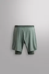 Shorts de entrenamiento azul marino con calza interior negra. Cintura elástica ajustable con cordón, bolsillos laterales con cierre y aberturas laterales en el bajo.