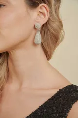 Caravanas colgantes con diseño de dos piezas: un tope circular superior y un dije inferior en forma de gota, ambos completamente cubiertos de cristales brillantes.