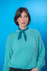 Sweater color beige de lana mohair y acrílico, con cuello redondo y mangas largas.