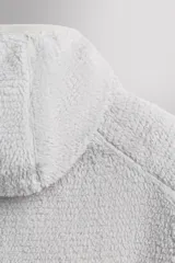 Sudadera regular fit de tejido polar con textura efecto pelo, color gris claro. Cuenta con cuello subido, capucha ajustada, manga larga ranglán, bolsillos laterales en la cadera y bajo asimétrico más largo en la espalda. Los acabados son con cinta elástica.