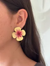 Aro con forma de flor pintada a mano en tonos amarillos y fucsia, con detalles de brillo y mostacillas en el centro.