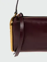 Cartera tipo shoulder bag Marc Jacobs modelo The Puffy J Marc, de cuero color bordó con detalles metálicos dorados.