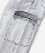 Pantalón de jean modelo baggy con bolsillos cargo laterales, cintura con trabillas y cierre frontal con botón y cremallera.