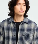 Camisa de franela a cuadros azul marino y beige, de corte comfort, con cuello inglés, abotonadura frontal, manga larga y bolsillo en el pecho.