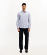 Camisa de vestir para hombre, de manga larga y calce clásico, confeccionada en tricolina de algodón y poliéster, con diseño de cuadros grid en tono celeste claro. Presenta cuello camisero, cierre frontal con botones y puños ajustables con botón único.
