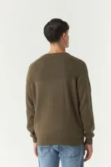Sweater color verde oliva con textura acanalada en la parte superior del pecho y hombros.