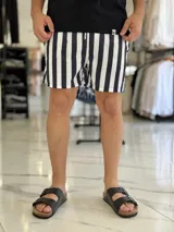 Short de baño con diseño de rayas verticales en color azul marino y blanco, con cintura elástica y cordón ajustable.