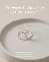 Anillo de acero plateado con diseño de serpiente texturizada y cuerpo de cuentas esféricas, ajustable.