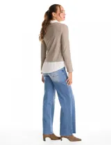 Buzo combinado marca Rio & Rian, con diseño de efecto capas que simula una camisa blanca debajo. Presenta un cuerpo de tejido de hilado fino en color beige con escote en V, y cuello y ruedo de gasa blanca.