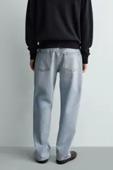 Pantalón de jean color celeste con efecto lavado, de corte recto y tiro medio, con diseño de cinco bolsillos y cierre frontal con botones.