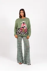 Sweater de punto color verde, tejido y bordado a mano, con diseño gráfico artesanal en el frente y mangas largas.